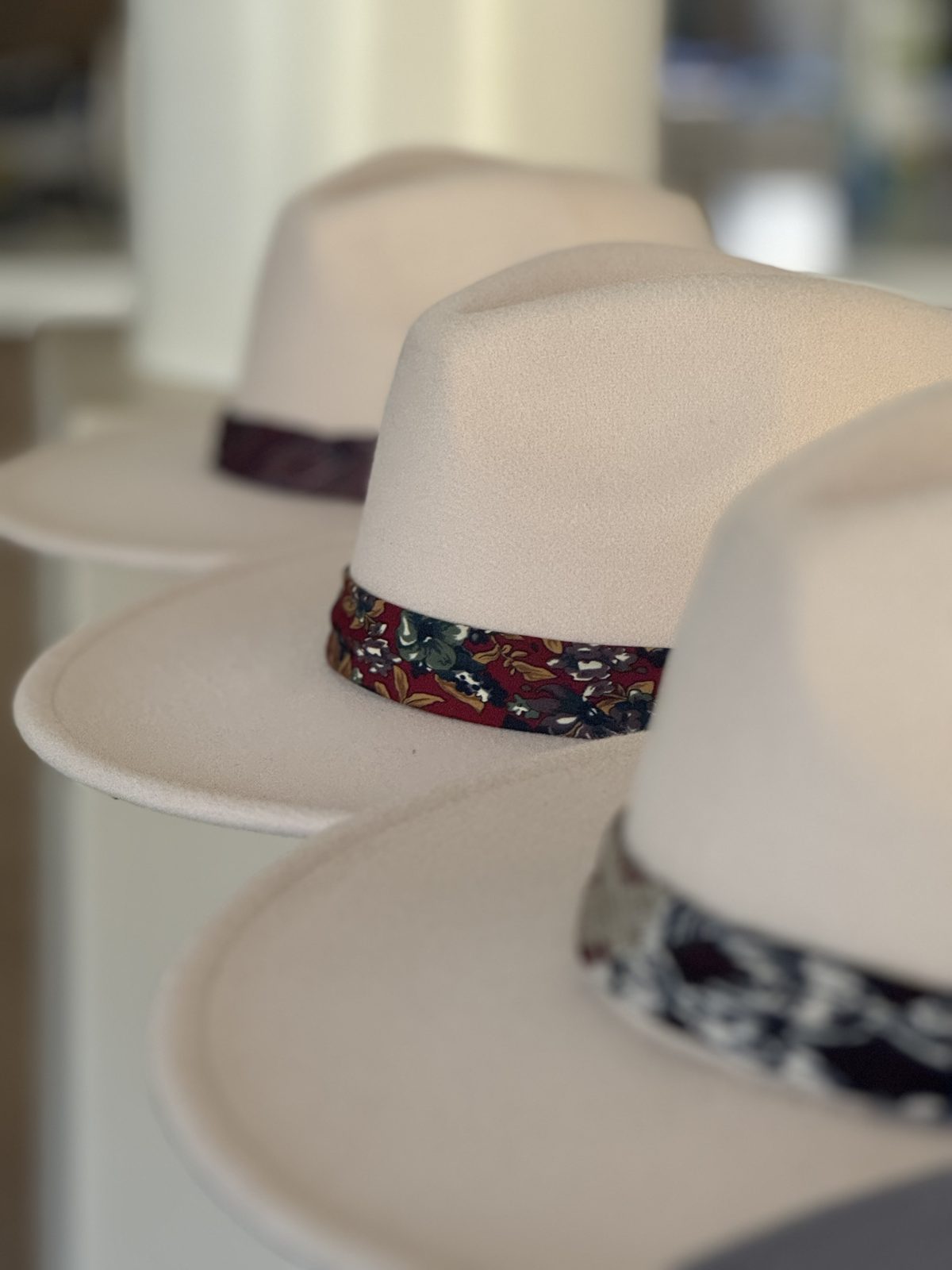 Row of cream fedoras with patterned bands