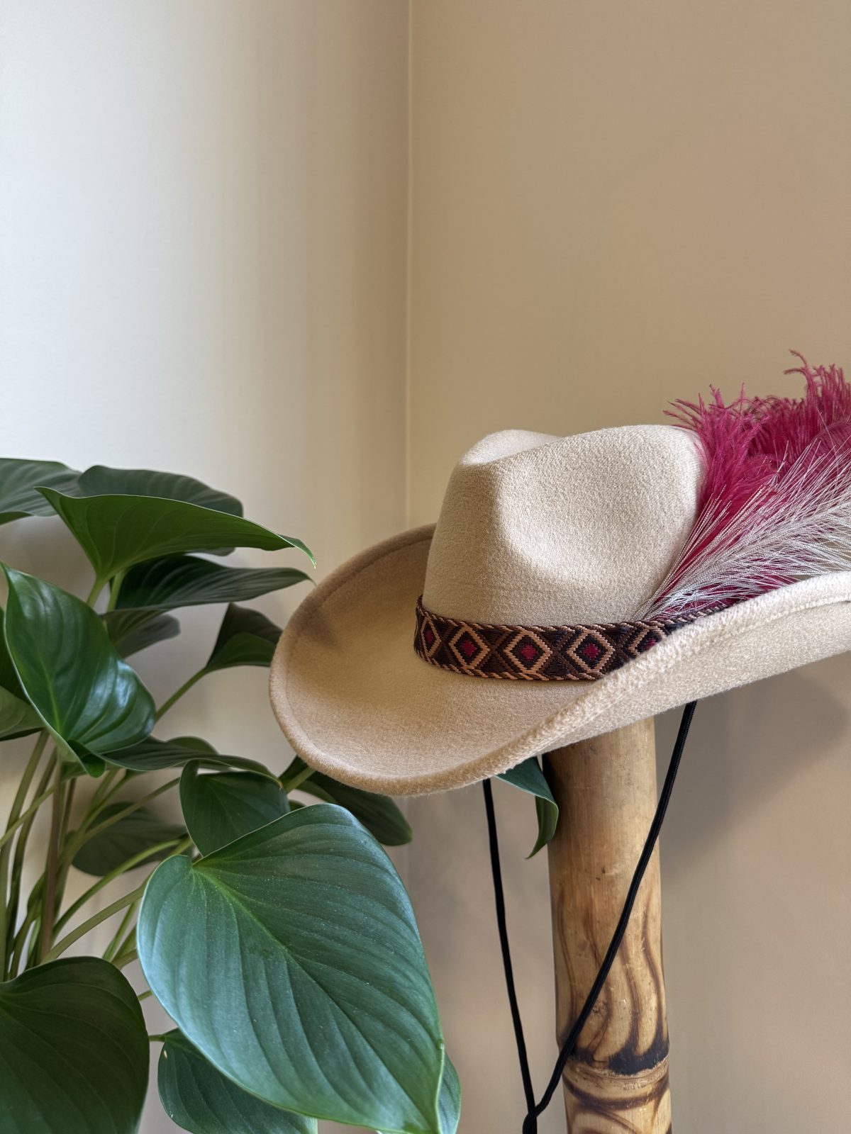 Cream fedora with patterned band and red feather