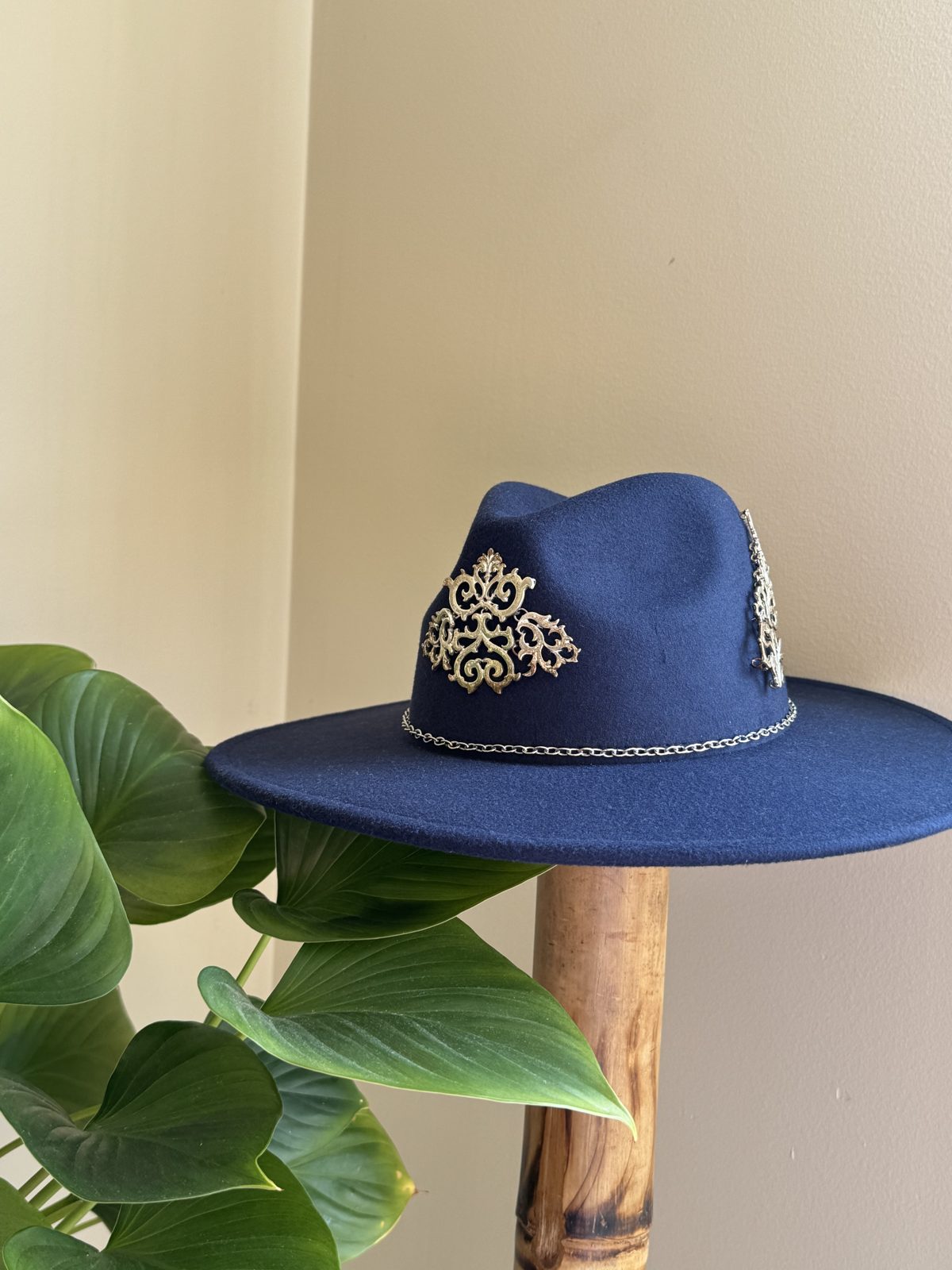 Navy fedora with ornate cross pendant