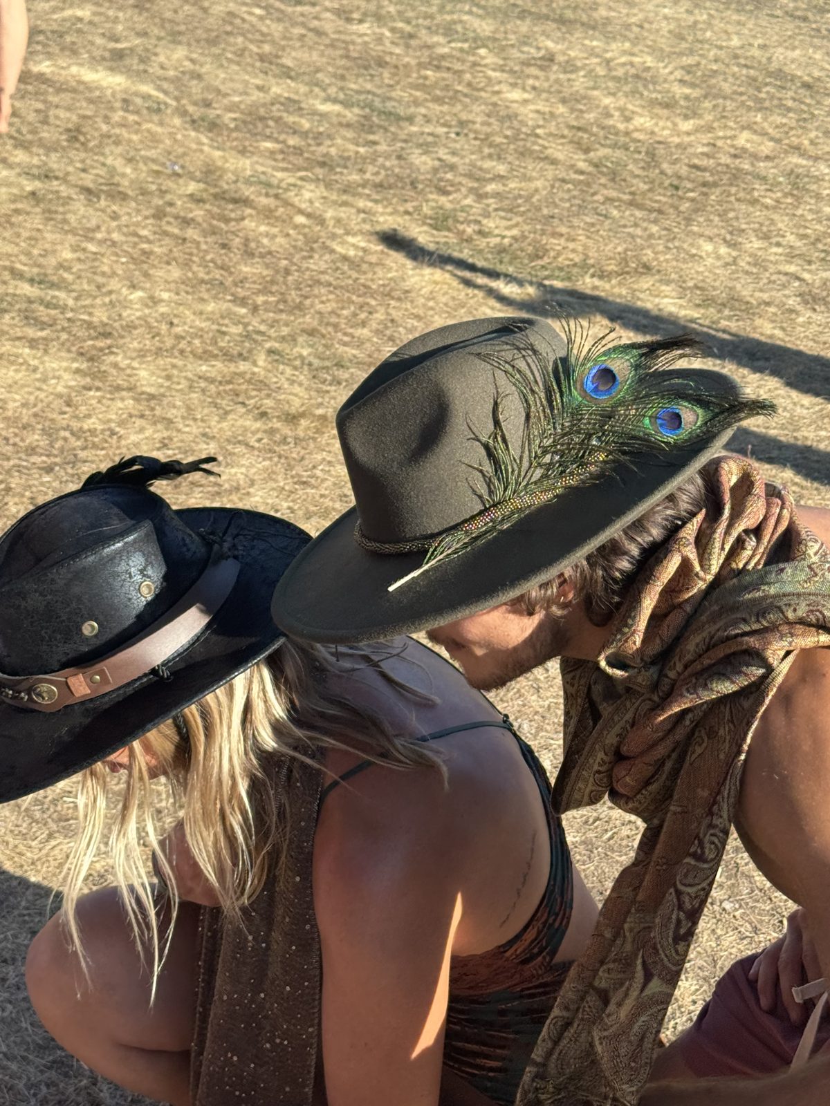 People at a festival wearing hats with feather details
